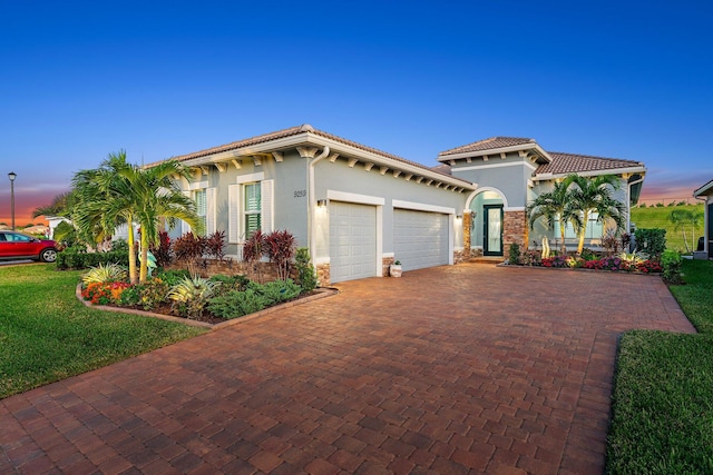 mediterranean / spanish-style home with a lawn and a garage