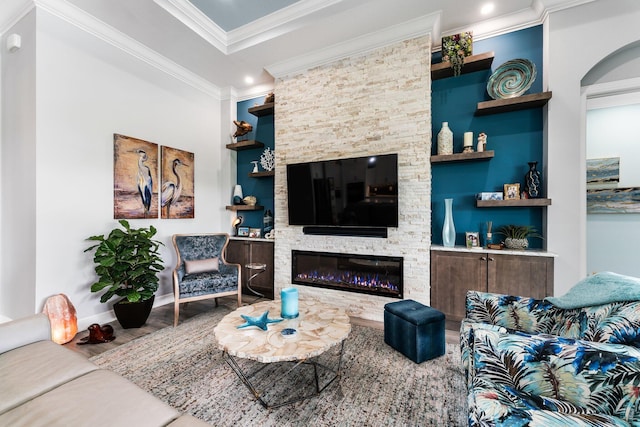 living room with built in shelves, crown molding, and a fireplace