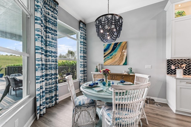 dining room featuring a chandelier, dark hardwood / wood-style floors, and crown molding