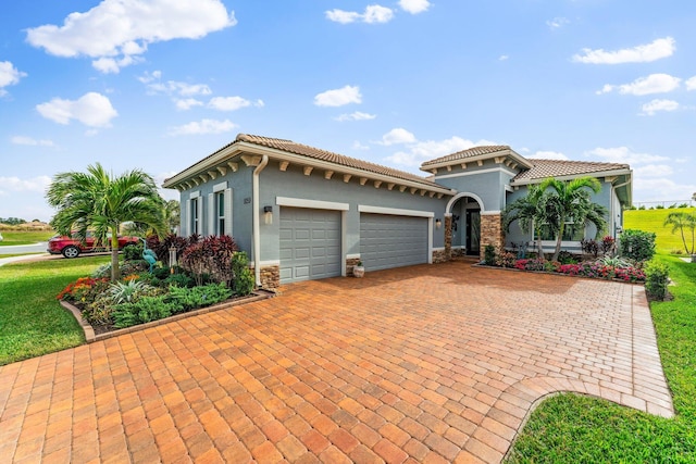 mediterranean / spanish-style house featuring a garage and a front yard