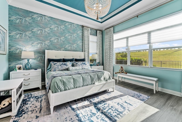 bedroom with hardwood / wood-style flooring, a notable chandelier, and ornamental molding