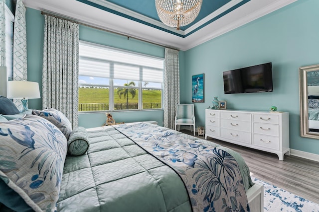 bedroom featuring wood-type flooring, crown molding, and a chandelier