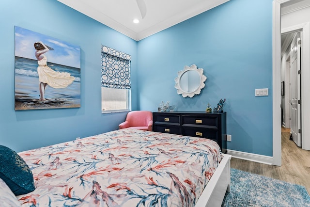 bedroom featuring wood-type flooring, ceiling fan, and crown molding