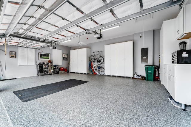 garage featuring electric panel, ceiling fan, and a garage door opener