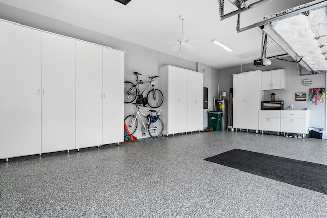 garage with electric panel, a garage door opener, ceiling fan, and water heater