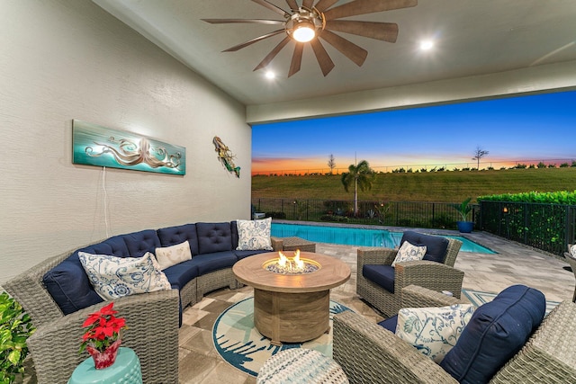 pool at dusk featuring an outdoor fire pit and a patio area