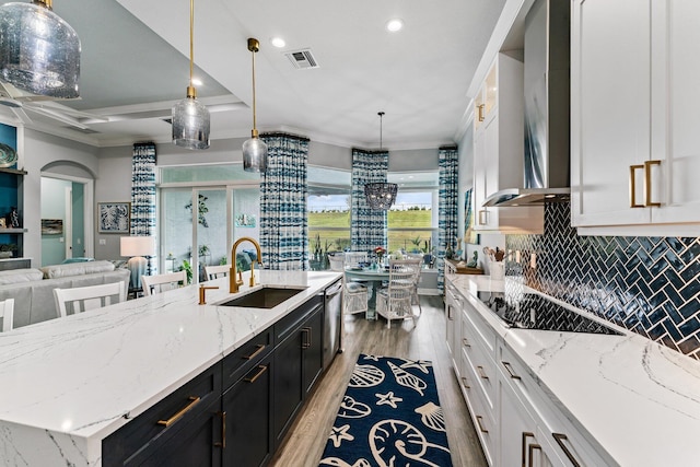 kitchen featuring a kitchen island with sink, white cabinets, and pendant lighting