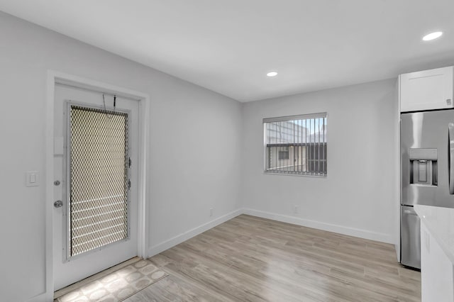 empty room featuring light wood-type flooring, baseboards, and recessed lighting