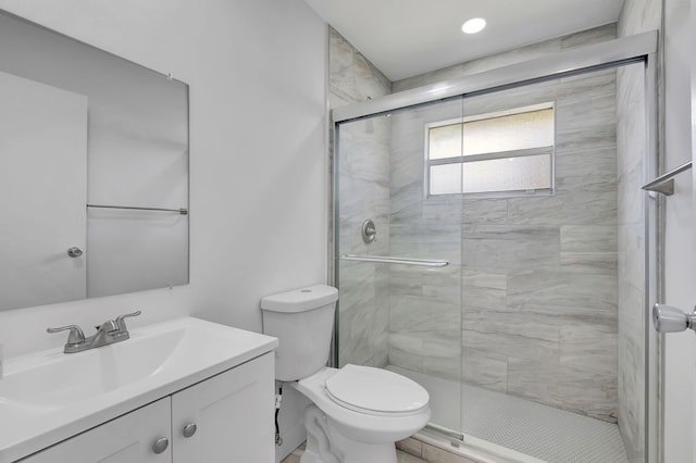 bathroom featuring vanity, toilet, and a shower with door