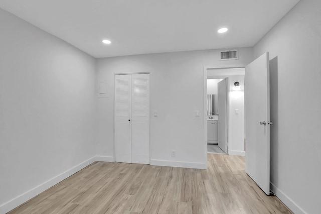 unfurnished bedroom featuring light hardwood / wood-style floors and a closet