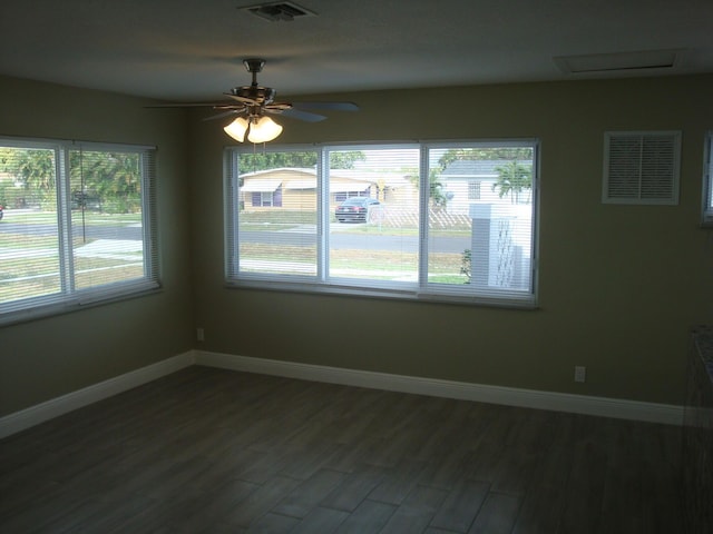 unfurnished room with ceiling fan, dark hardwood / wood-style floors, and a wealth of natural light