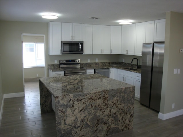 kitchen featuring stainless steel appliances, white cabinetry, and sink