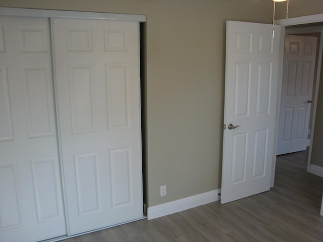 unfurnished bedroom with hardwood / wood-style floors and a closet