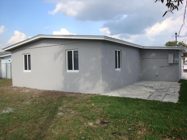 view of side of property with a lawn and a patio area