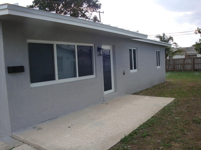 rear view of property with a lawn and a patio