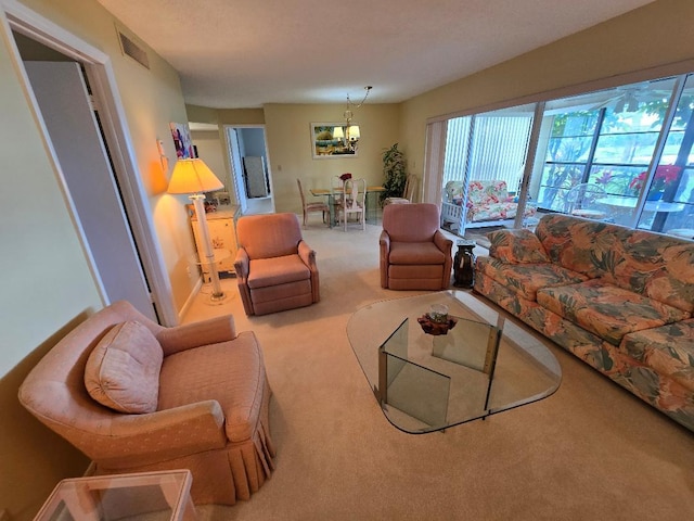 carpeted living room featuring a chandelier