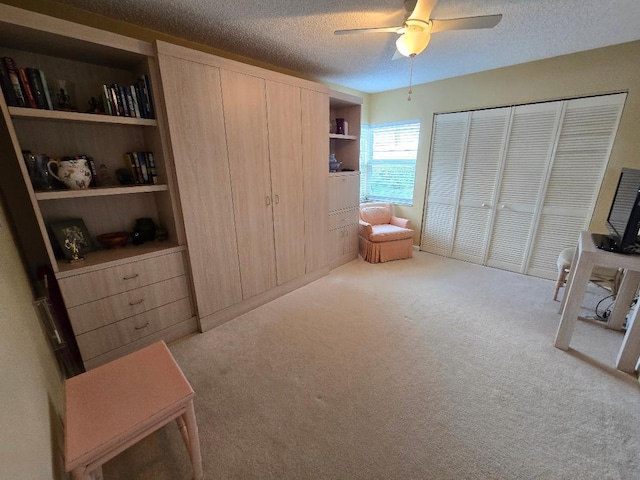 carpeted bedroom featuring ceiling fan, a textured ceiling, and a closet