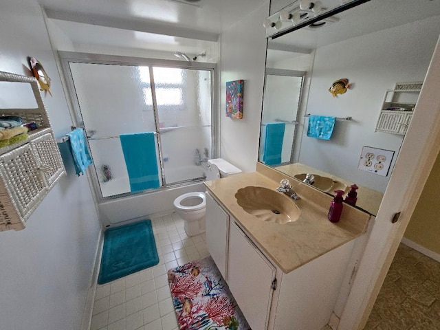 full bathroom featuring combined bath / shower with glass door, tile patterned floors, vanity, and toilet