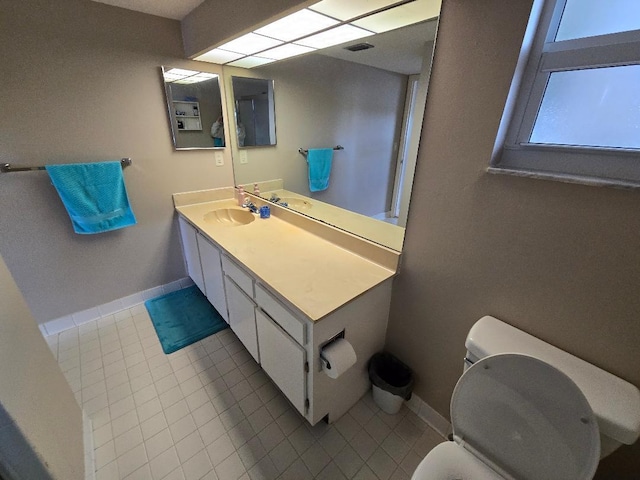 bathroom featuring tile patterned flooring, vanity, and toilet