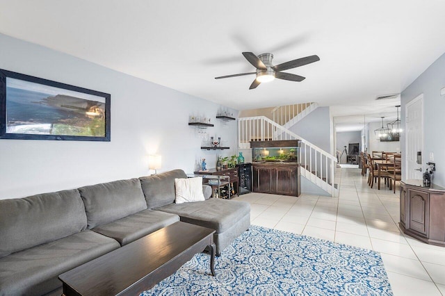 living room featuring ceiling fan with notable chandelier and light tile patterned flooring