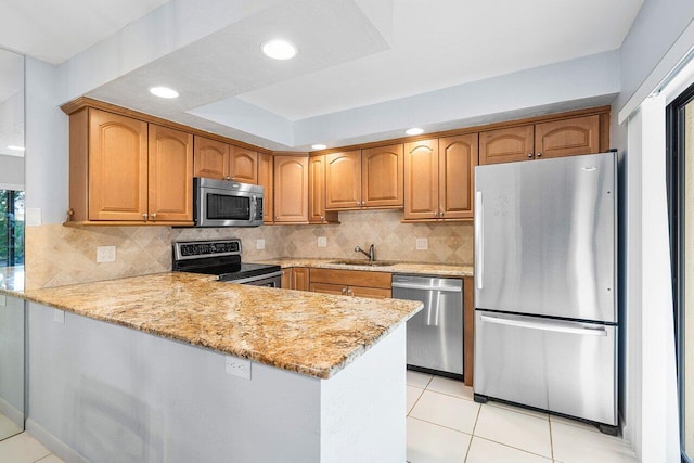 kitchen featuring kitchen peninsula, light stone countertops, sink, and appliances with stainless steel finishes