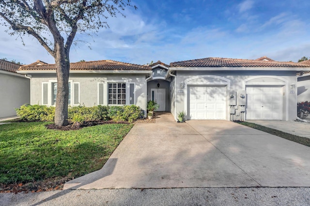 mediterranean / spanish home featuring a garage and a front lawn