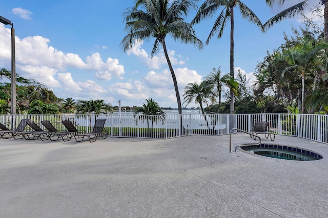 view of swimming pool with a water view and a hot tub