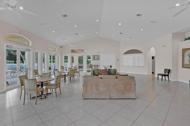 tiled living room featuring ceiling fan, french doors, and a towering ceiling