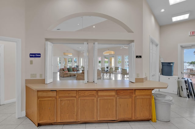 kitchen with light tile patterned floors, french doors, high vaulted ceiling, and ceiling fan