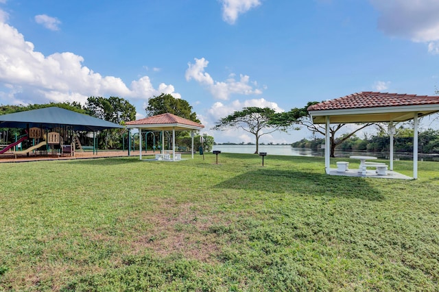 view of yard with a gazebo, a playground, and a water view