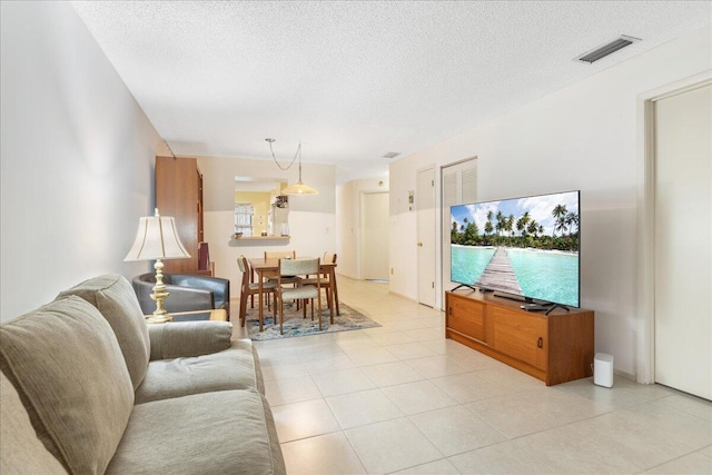 tiled living room featuring a textured ceiling