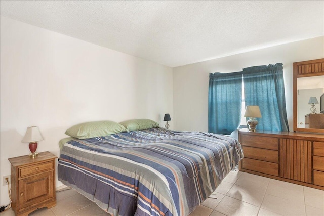 bedroom with light tile patterned flooring and a textured ceiling