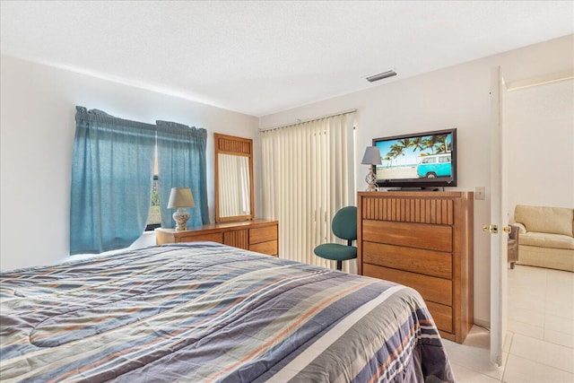 bedroom with light tile patterned floors and a textured ceiling