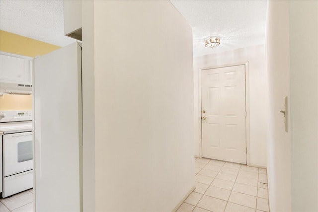 hallway with light tile patterned floors and a textured ceiling