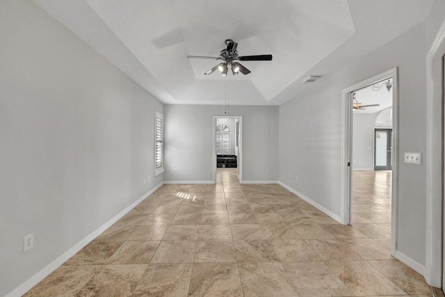 spare room with a tray ceiling and ceiling fan