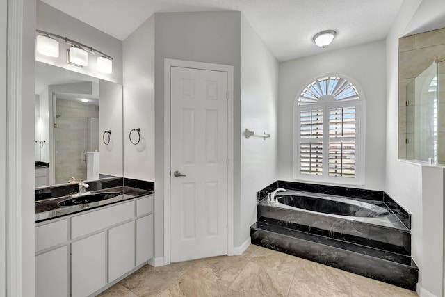 bathroom with vanity, a textured ceiling, and shower with separate bathtub