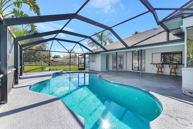 view of swimming pool featuring a lanai, a patio area, and french doors