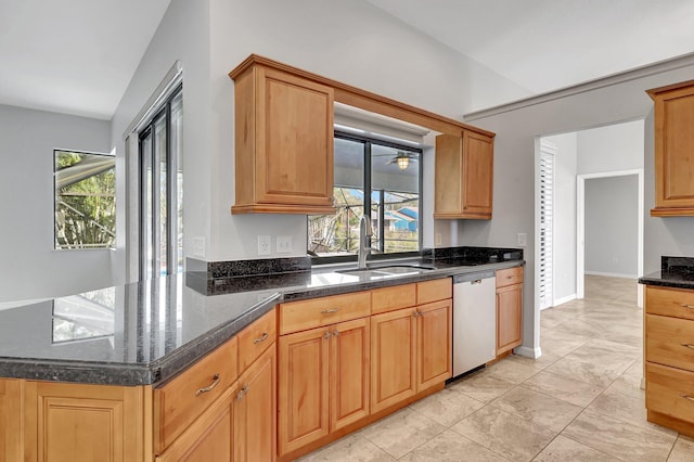 kitchen featuring dishwasher, sink, dark stone countertops, light tile patterned flooring, and kitchen peninsula