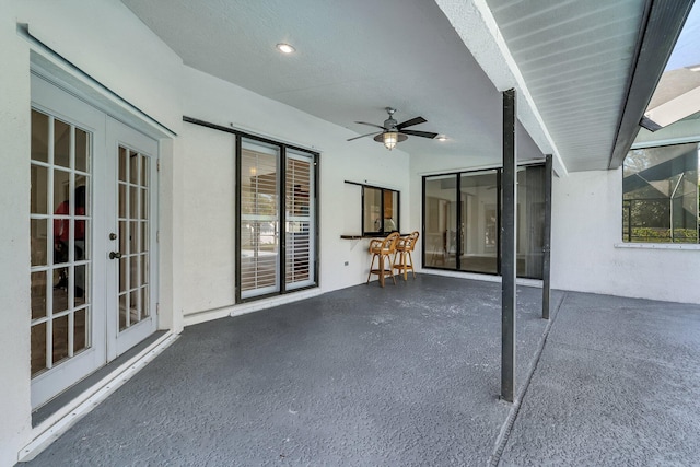 view of patio / terrace with ceiling fan, a lanai, and french doors