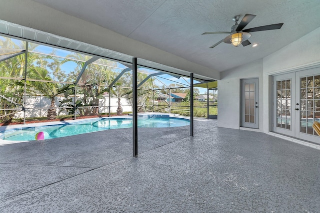 view of swimming pool featuring ceiling fan, a lanai, a patio, and french doors