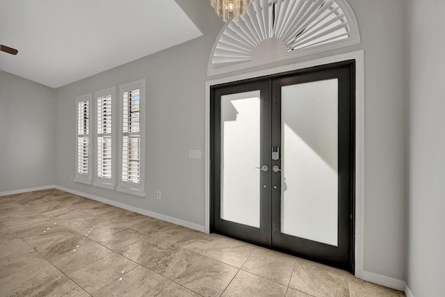 entryway with french doors and a notable chandelier