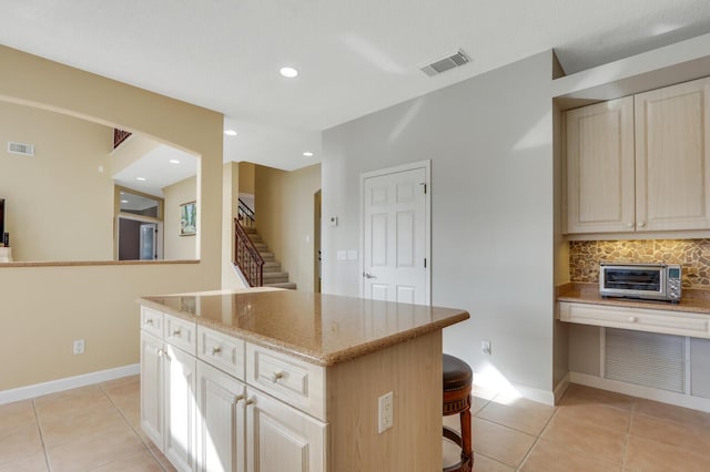 kitchen featuring light tile patterned floors, a toaster, visible vents, and baseboards