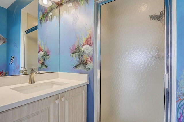 bathroom with a shower stall and vanity