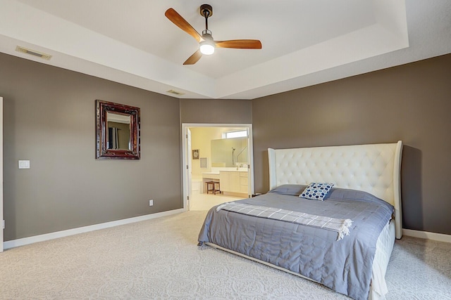 bedroom with carpet, baseboards, visible vents, and a raised ceiling