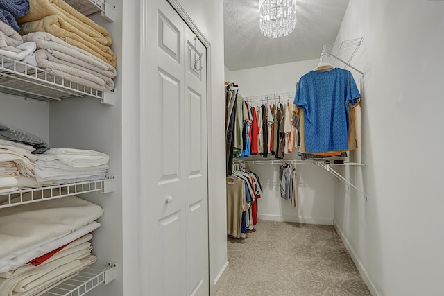 walk in closet with a chandelier