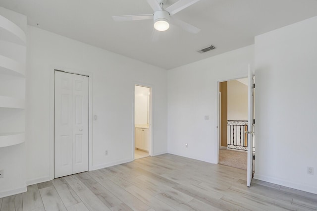 unfurnished bedroom with light wood-style floors, visible vents, ceiling fan, and ensuite bath