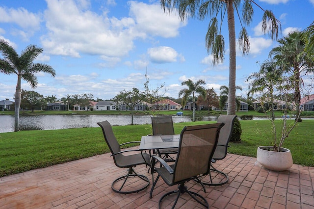 view of patio / terrace with a water view, a residential view, and outdoor dining space