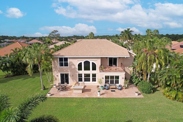 back of house with a balcony, a tile roof, a yard, a patio area, and an outdoor living space