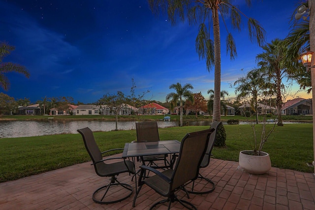 view of patio with a water view and outdoor dining space