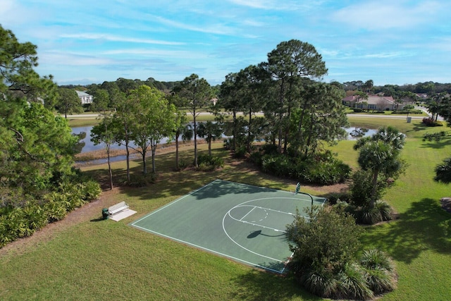 view of basketball court featuring a water view, community basketball court, and a yard